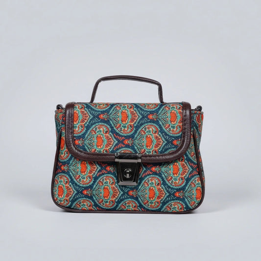 Front view of a small floral print crossbody sling bag with a button closure flap