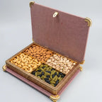 Open floral dry fruit box with four compartments displaying cashews, almonds, pistachios and raisins