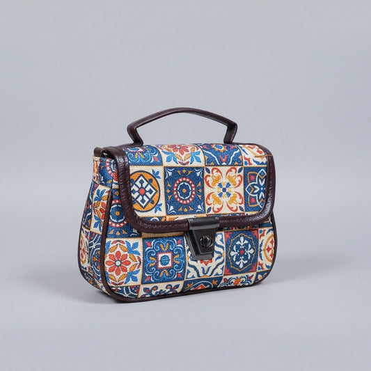 Front view of a small floral ethnic sling bag with button closure and handle
