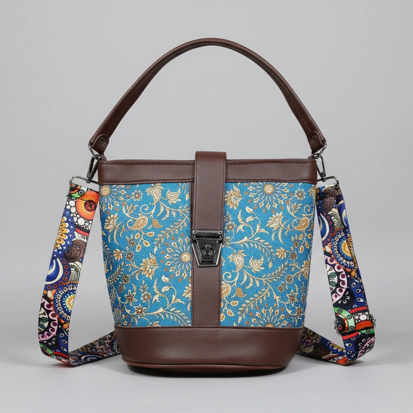 Front view of a 9x9 inch square sling bag featuring a vibrant floral print fabric and brown PU leather accents.