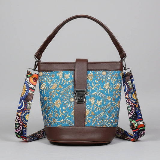 Front view of a 9x9 inch square sling bag featuring a vibrant floral print fabric and brown PU leather accents.