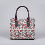 Front view of a premium floral print fabric handbag with PU leather handles.