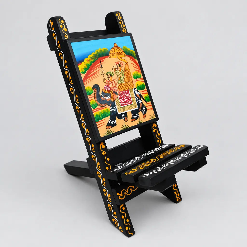 Foldable wooden mobile holder in a chair design with a Rajasthani elephant painting, shown at an angle.