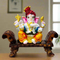 Unique resin Ganesha idol seated on a colorful designer sofa, hand-painted with vibrant traditional detailing.