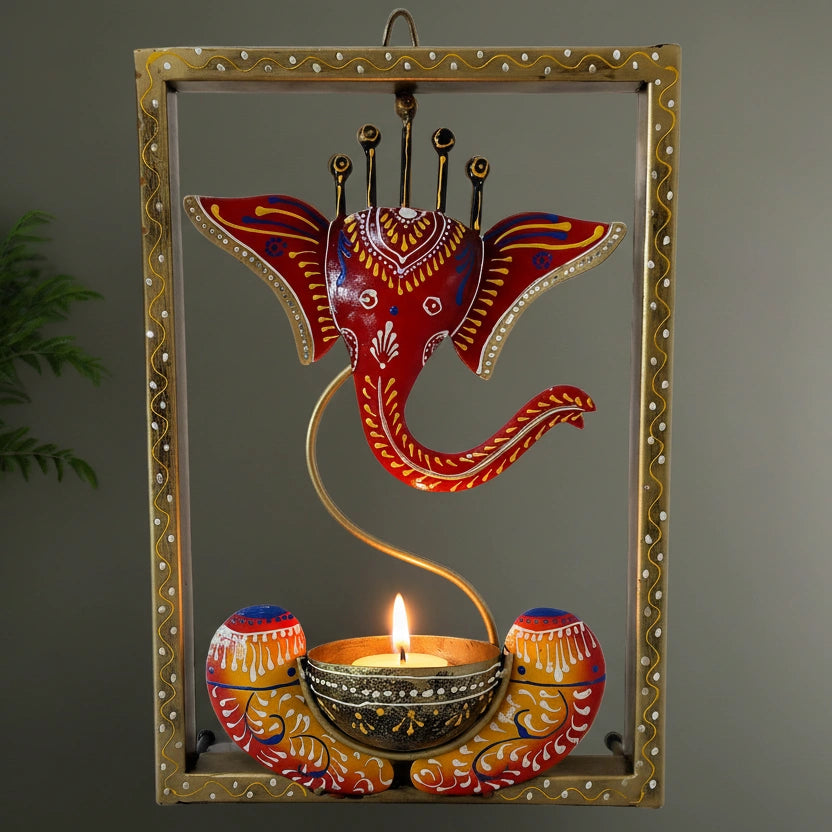 Hand-painted metal wall frame featuring Lord Ganesha with a built-in tealight candle stand.