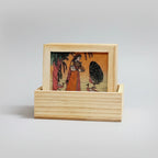 Engraved wooden holder displaying Bani Thani lady gemstone painted coasters, perfect Jaipur souvenir for coffee table elegance.