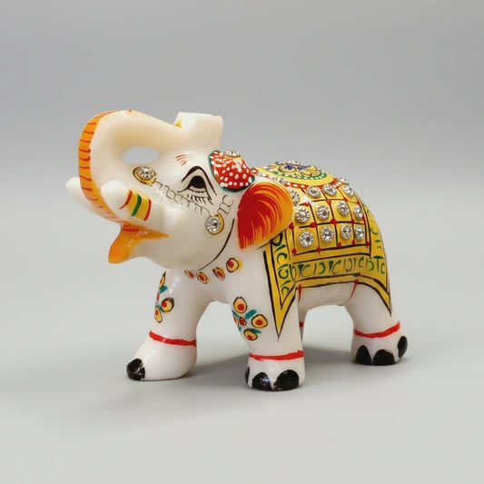 Close-up of hand-painted golden designs on a white Makrana marble elephant.