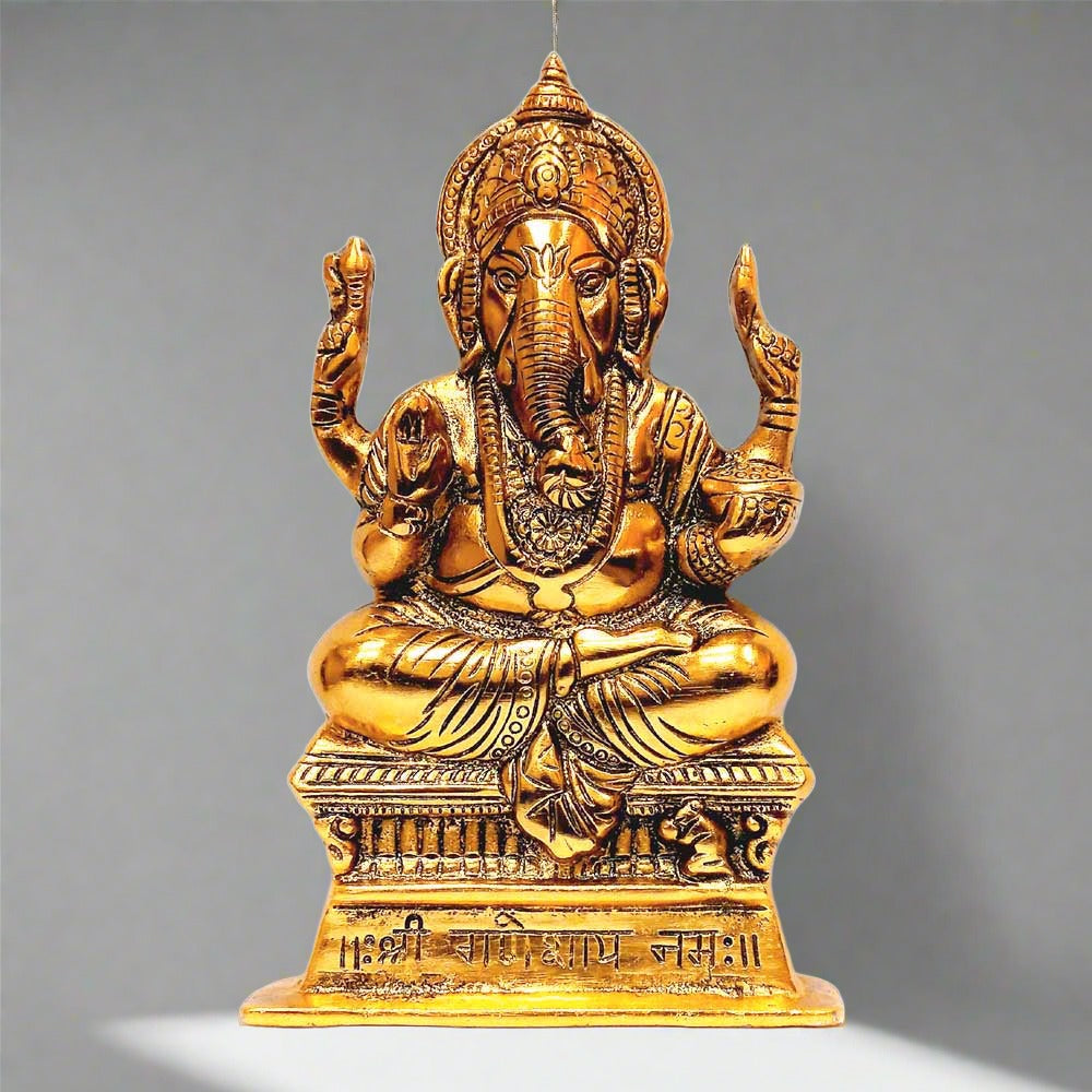 A golden metal Ganesh wall decor piece with an intricate traditional design.