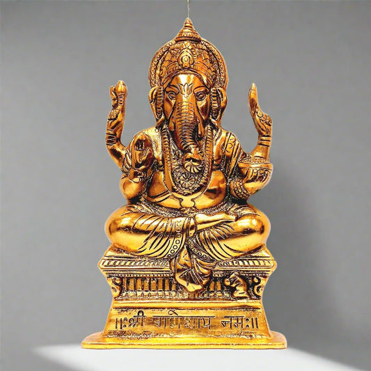 A golden metal Ganesh wall decor piece with an intricate traditional design.