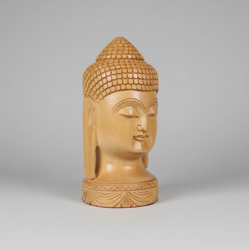 Side profile of a wooden Buddha bust highlighting the intricately etched elongated ears and the smooth curvature of the Kadamba timber.
