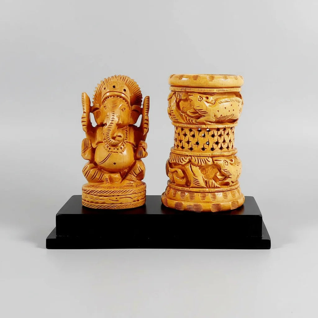 A handcrafted wooden pen holder featuring an intricately carved Lord Ganesh idol on a sturdy rectangular base.