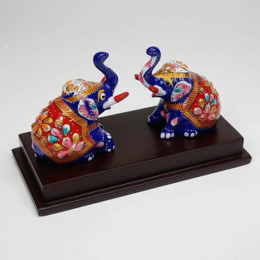 Detailed view of the intricate hand-painted enamel and Meenakari floral designs on the metal elephant.
