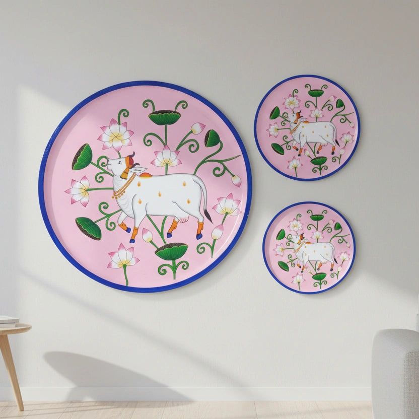 A vibrant, hand-painted Pichwai wall decor plate featuring a sacred Kamadhenu cow and lotus motifs, handmade by traditional artisans from Rajasthan.