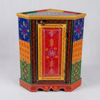 Front view of hand-painted wooden corner cabinet with a red floral door, multicolour side panels and gold-tone borders