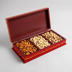Open hand-painted wooden dry fruit box with three compartments displaying almonds, cashews and pistachios