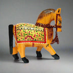 A hand-painted wooden horse showpiece decorated with golden, red, and green colors.