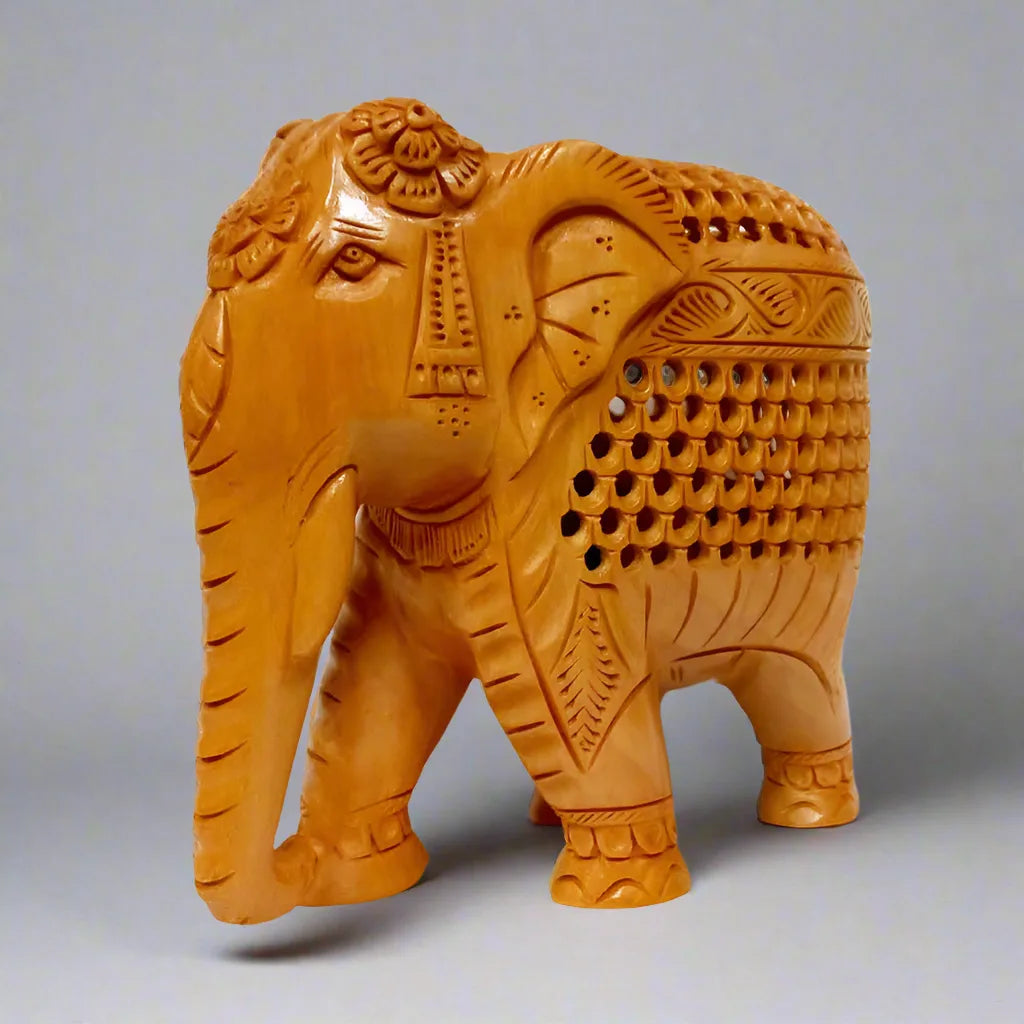 Hand-carved wooden elephant idol with intricate undercut design.