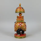Side profile of a black wooden elephant highlighting the golden spine and floral art.