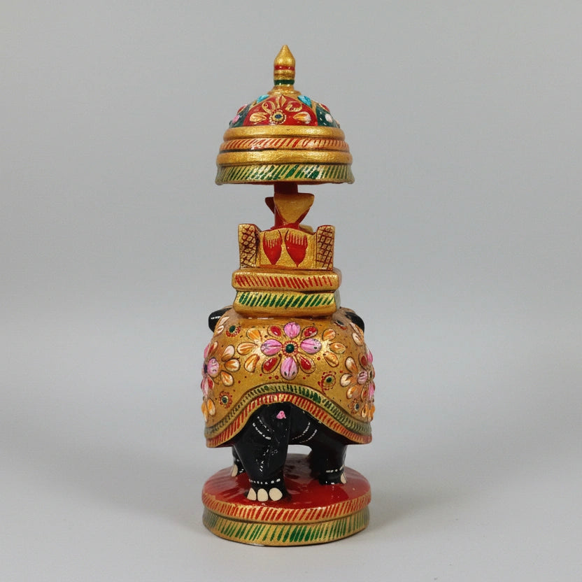 Side profile of a black wooden elephant highlighting the golden spine and floral art.