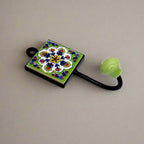 A handcrafted Blue Pottery wall art piece that functions as a hook.