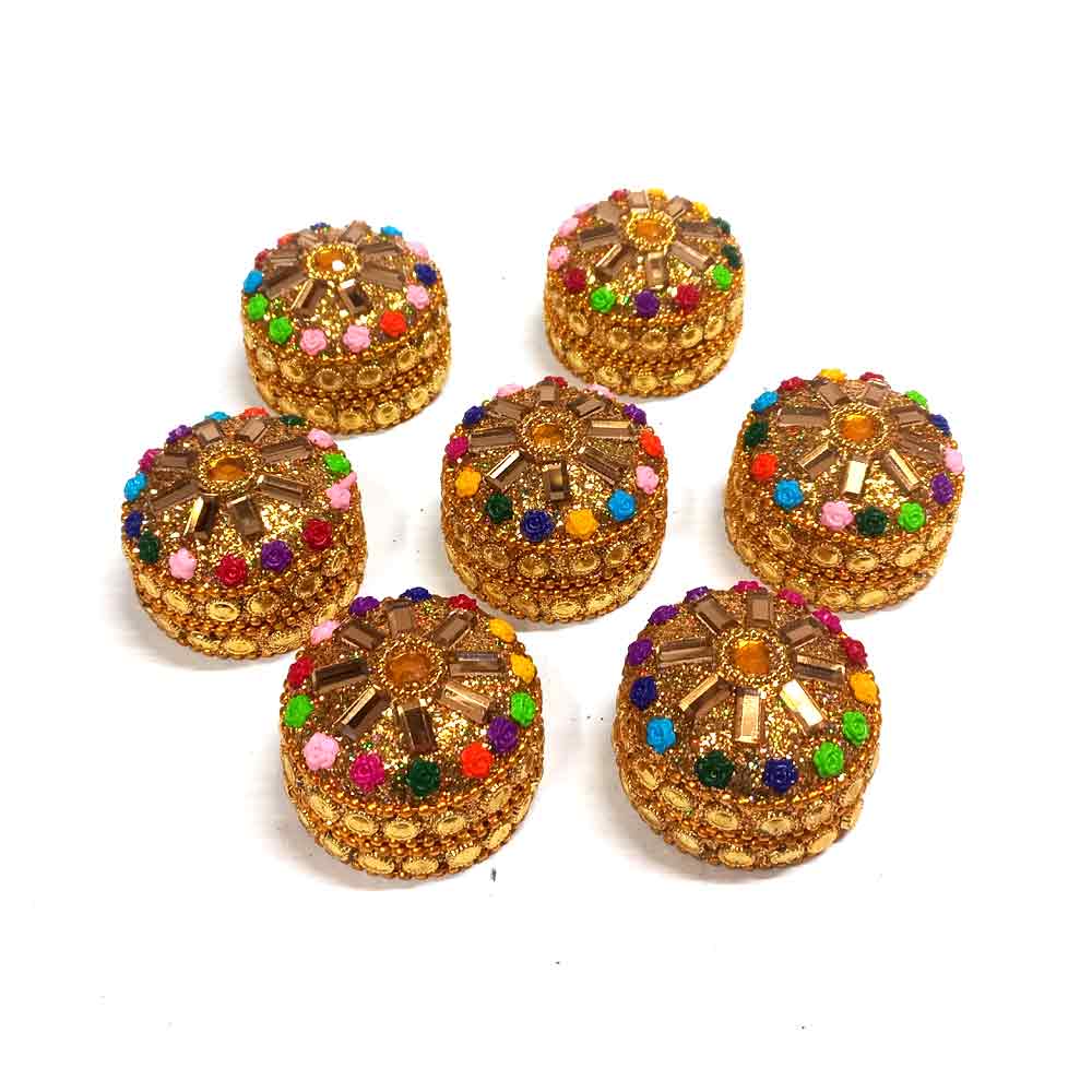 A handmade kumkum box with intricate details and a secure lid.