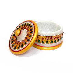 A handcrafted marble container for dry fruits, with intricate designs.
