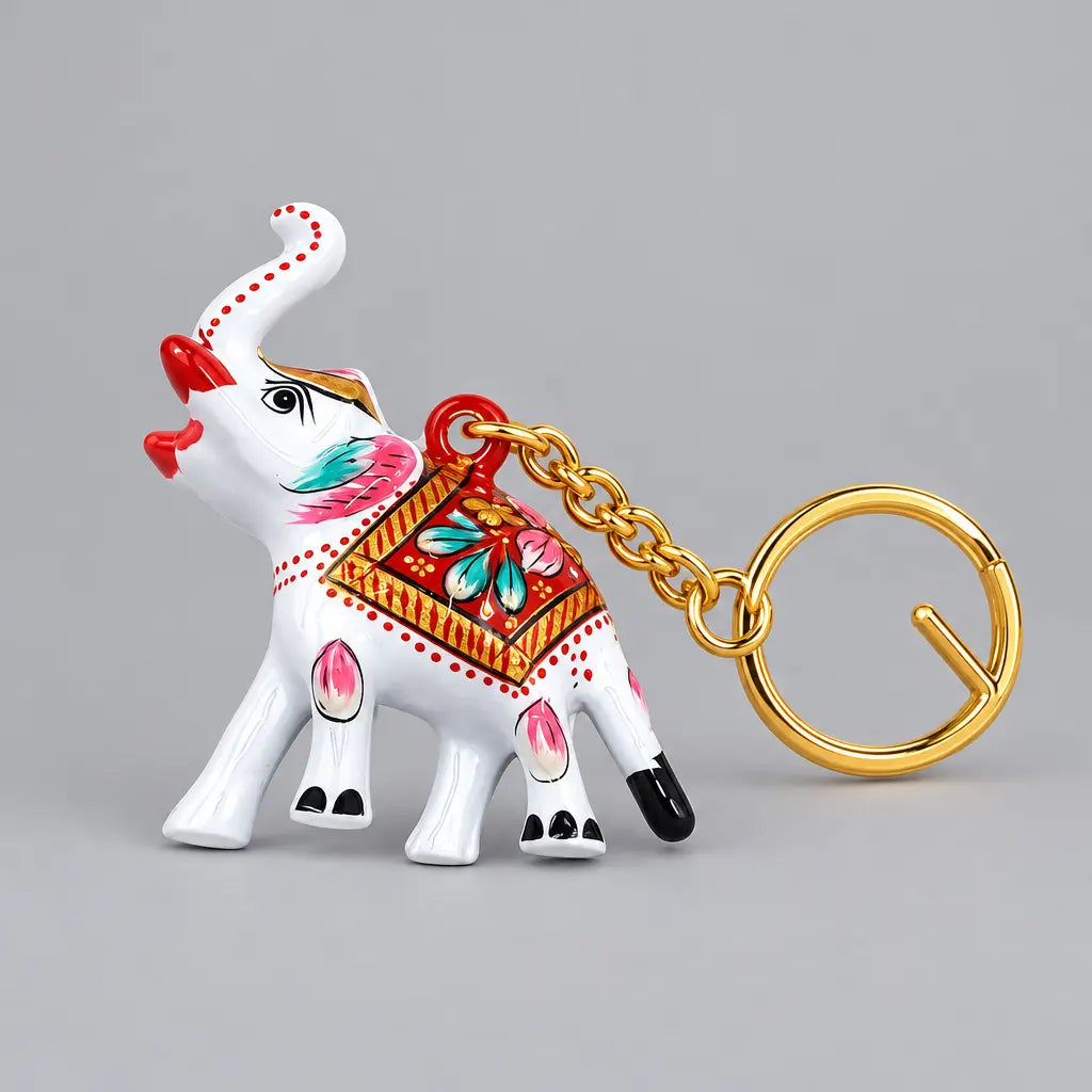 Side view of a handcrafted Meenakari elephant keychain with white enamel, colourful floral patterns and a gold-toned key ring extending to the right.