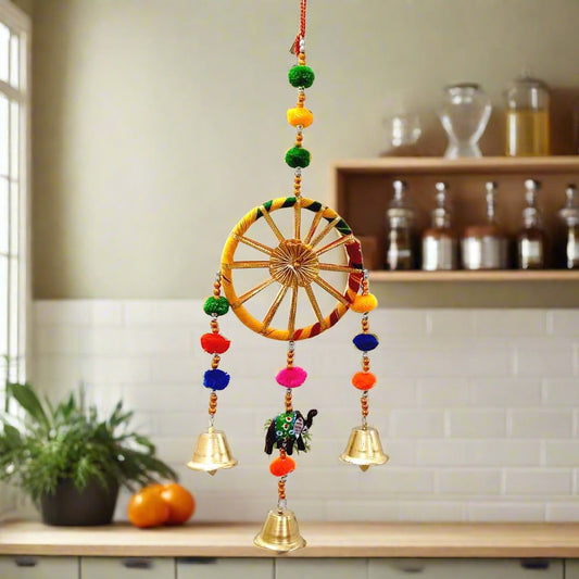 A handmade toran for wall decor, with intricate beadwork and colorful tassels.