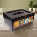 A handcrafted tissue box made from wood and decorative blue pottery tiles.
