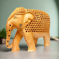 A handcrafted wooden elephant with a calf carved inside, featuring detailed carvings on its body.
