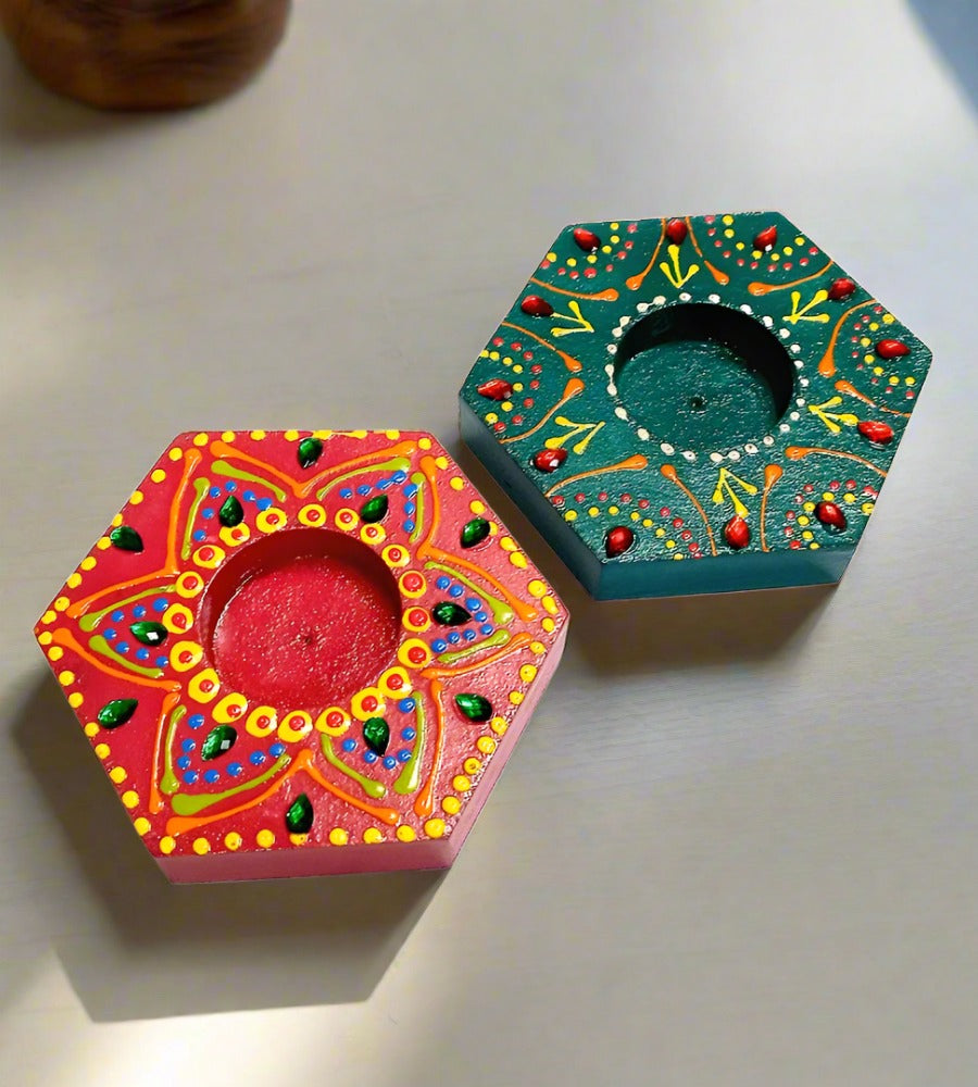 A handcrafted pair of wooden tea light holders, painted with intricate designs.
