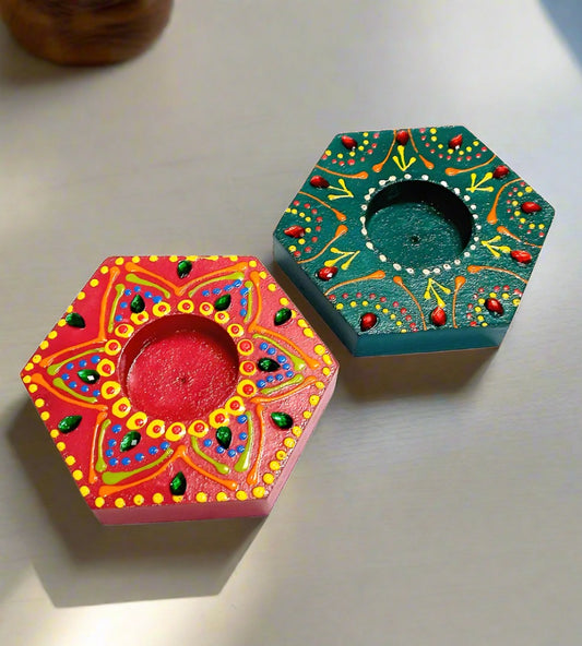A handcrafted pair of wooden tea light holders, painted with intricate designs.