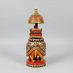 Rear profile of a wooden elephant showing continuous hand-painted designs and gold-colored accents.