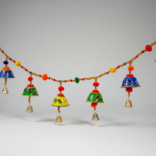 Handmade Bandarwal toran made of papermache featuring colorful hand paintings, bells, and pom-poms.