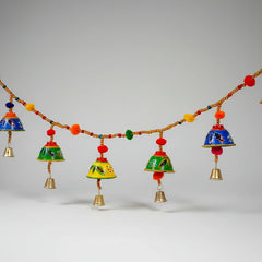Handmade Bandarwal toran made of papermache featuring colorful hand paintings, bells, and pom-poms.