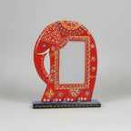 Traditional Indian folk art style picture frame in the shape of a red elephant, decorated with vibrant hand-painted floral motifs and textured emboss patterns.