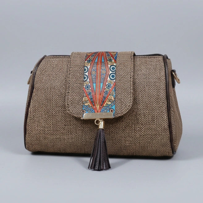 Close up of magnetic closure on a printed jacquard fabric crossbody bag