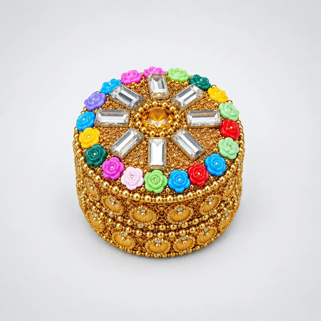 Round gold-toned kumkum box with colourful roses and rectangular stones on the lid