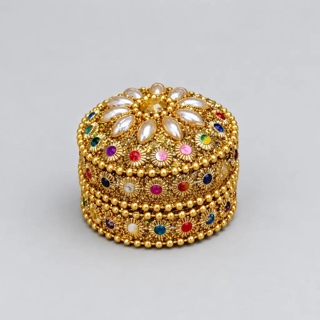 Closed gold-toned kumkum box with pearl-like petals and multicolour stone detailing
