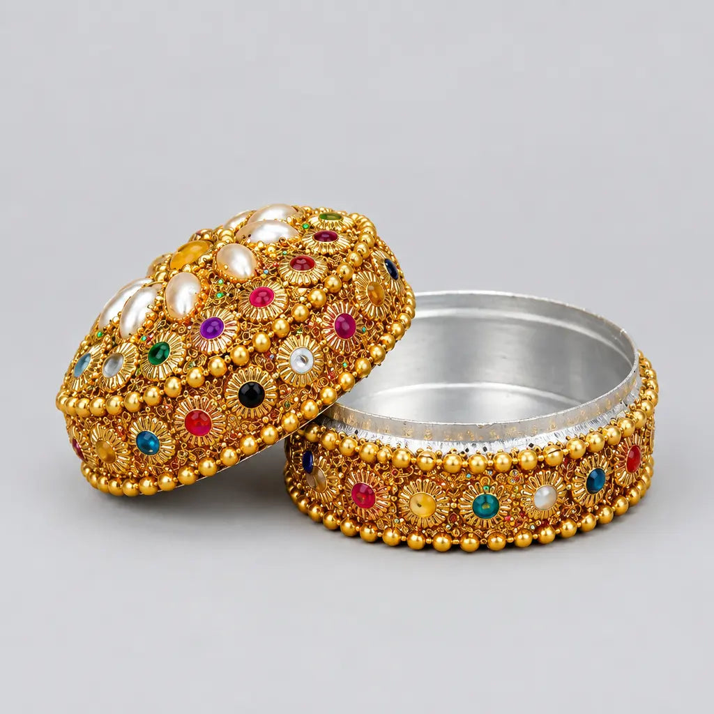 Open kumkum box with a silver-coloured interior and pearl-like petal decoration on the lid