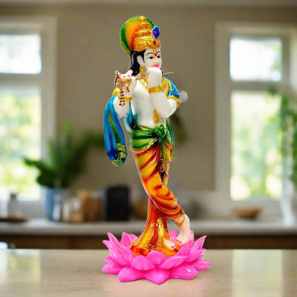 A Krishna statue with a flute decorated with stones, standing gracefully on a lotus flower.