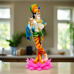 A Krishna statue with a flute decorated with stones, standing gracefully on a lotus flower.