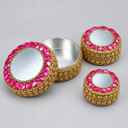 Three round lac kumkum boxes with closed mirror lids, decorative stone borders and golden-coloured sides.