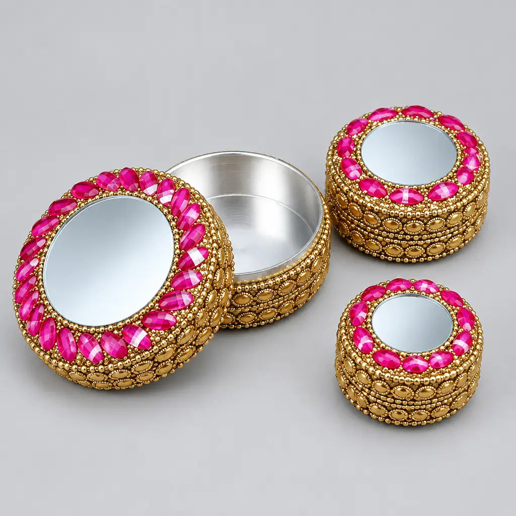 Three round lac kumkum boxes with closed mirror lids, decorative stone borders and golden-coloured sides.
