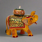 Decorative wooden candle holder shaped like a long trunk elephant, adorned with intricate traditional colors and hand art.