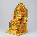 Lord Kuber statue viewed from the right, showing the crown, raised hand and ornate throne