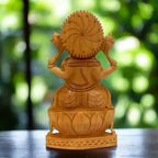 Back view of wooden Ganesh idol showing a circular carved halo, garment patterns and lotus pedestal