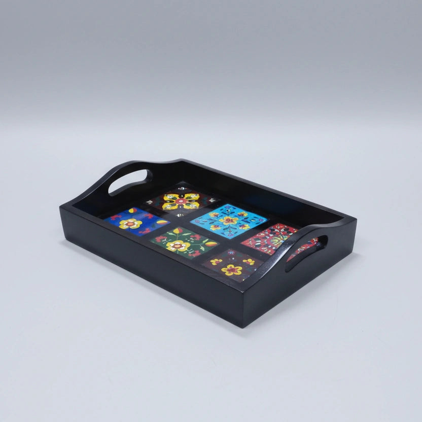 A 30cm handcrafted wooden tray with ceramic inlays placed as a decorative centerpiece on a modern coffee table.