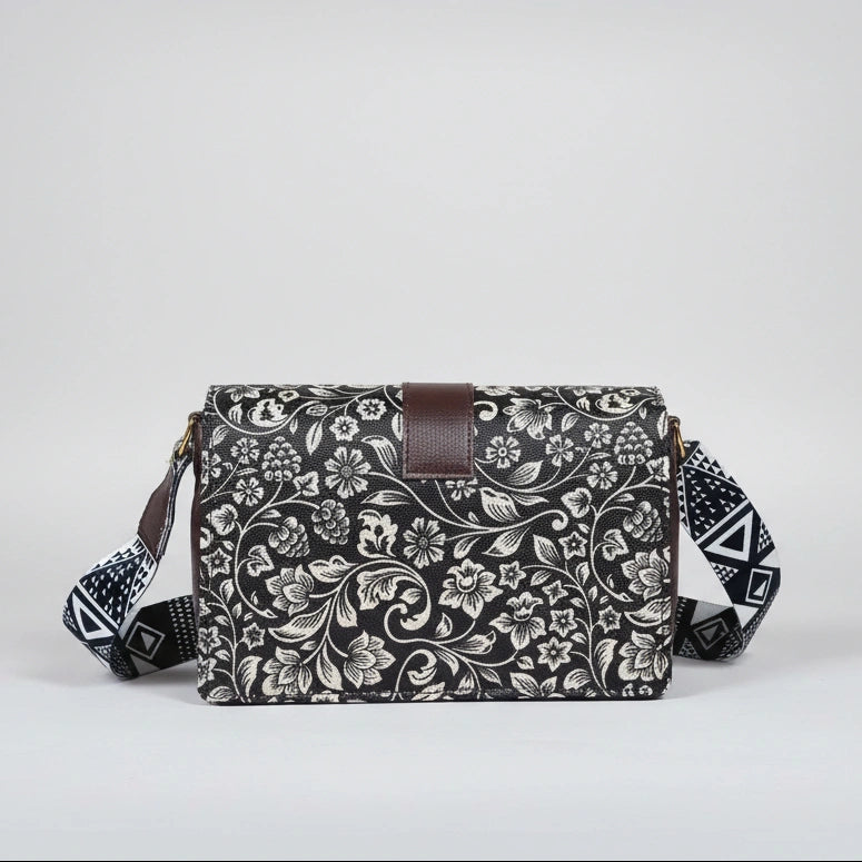 Close-up of the intricate black and white botanical woven pattern and magnetic button closure.
