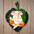 A marble dust Ganesha wall hanging, featuring Lord Ganesha on a green peepal leaf.